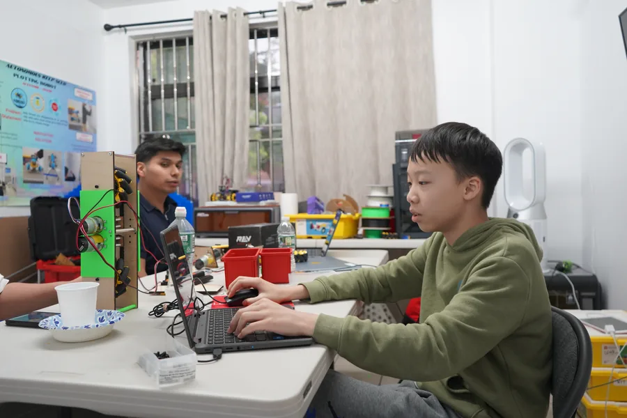AI Future student coding while testing a robot project