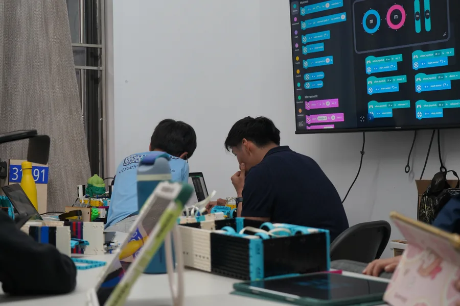 AI Future students coding and troubleshooting robotics projects with instructor support